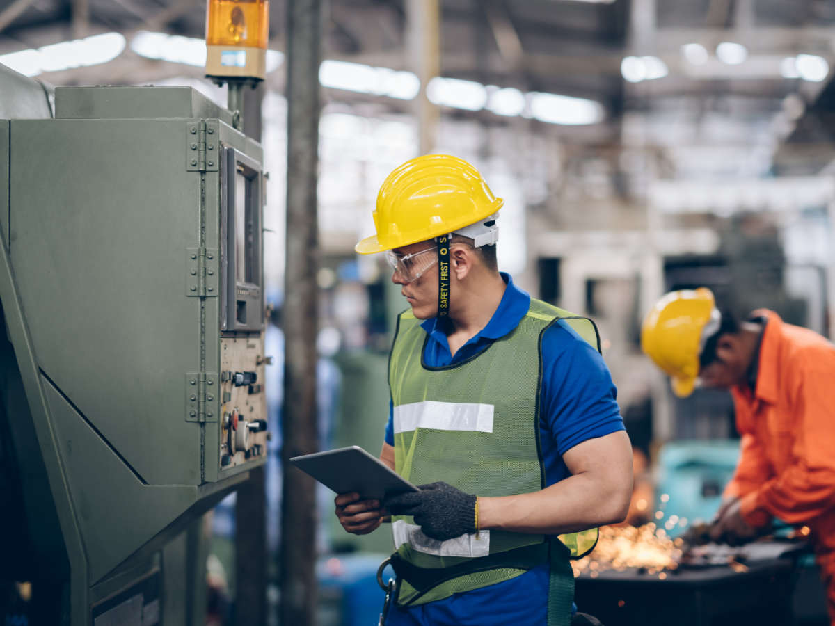 technician engineer checking process on tablet to machinery in factory